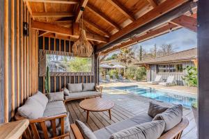 an outdoor patio with a couch and a table and a pool at VillaCanau in Lacanau