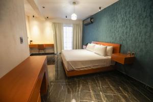 图斯特拉古铁雷斯Mandarina's House Hotel的一间带床和蓝色墙壁的卧室