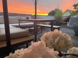 un patio con sofá, mesa y flores en Dachwohnung mit Sonnenterrasse, en Flörsheim