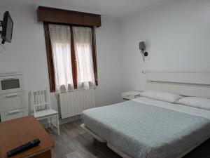 a bedroom with a bed and a table and a window at Akelarre Ostatua in Guernica y Luno