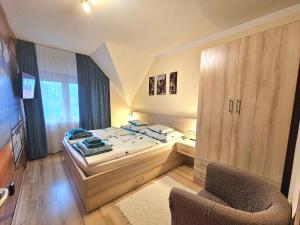 sypialnia z łóżkiem i krzesłem w obiekcie Apartman Siesta Bük - Bükfürdő w mieście Bük
