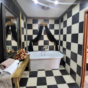 a bathroom with black and white checkered walls and a tub at Excalibur Boutique Hotel in Rustenburg +26 photos