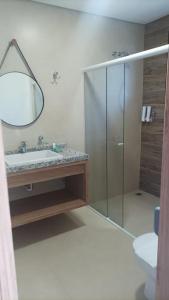 ein Badezimmer mit Glasdusche und Waschbecken in der Unterkunft Capivari ecoresort residence in Campina Grande do Sul