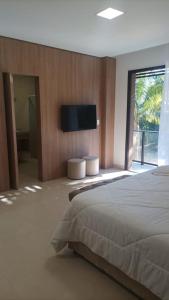 ein Schlafzimmer mit einem Bett und einem Flachbildfernseher in der Unterkunft Capivari ecoresort residence in Campina Grande do Sul