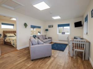 a living room with a couch and a table at Kingfisher Lodge in St Austell