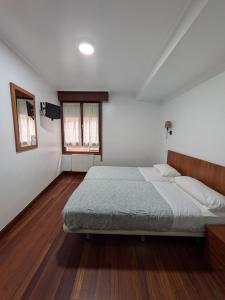 a bedroom with a large bed in a room at Akelarre Ostatua in Guernica y Luno