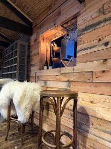a room with a wooden wall with a table and stool at The Historical Trick Hut in the middle of the Lake in Baambrugse Zuwe +60 photos