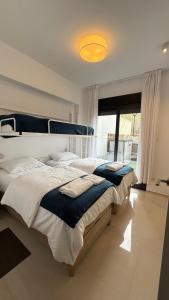 a bedroom with two beds and a large window at Seaside Apartment in Arenales del Sol