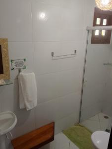 a white bathroom with a shower and a sink at Beija Flor in Pipa +32 photos