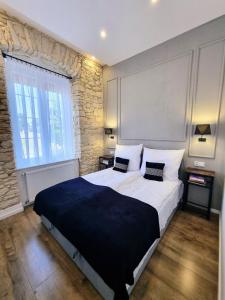 ein Schlafzimmer mit einem großen Bett und einer Steinwand in der Unterkunft Biały Kruk Apartamenty vis-a-vis Jasnej Góry 2a in Częstochowa