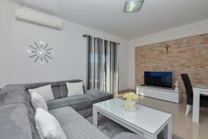 a living room with a couch and a table at Apartment Dijana with private pool in Donji Proložac