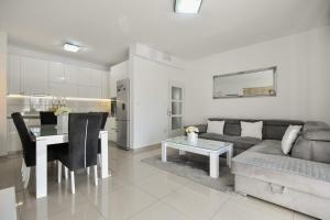 a living room with a couch and a table and a kitchen at Apartment Dijana with private pool in Donji Proložac