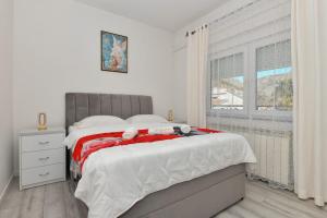 a bedroom with a large bed with a window at Apartment Dijana with private pool in Donji Proložac +17 photos