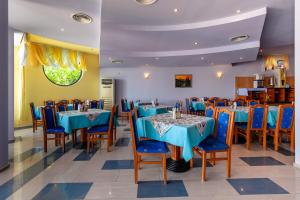 a dining room with blue tables and chairs at Hotel Evridika in Nesebar