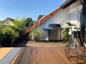 Un jarrón sobre una mesa de madera al lado de un edificio. en Dachwohnung mit Sonnenterrasse, en Flörsheim