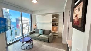 a living room with a couch and a large window at Sky-High oasis Large Studio POOL & GYM in Miami