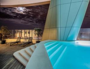 a glass building with two chairs on a deck at Nicosia 360 Luxury Living A in Nicosia