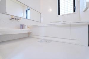ein weißes Badezimmer mit Waschbecken und Spiegel in der Unterkunft European villa in Tokio + 68 Fotos