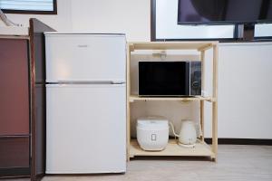 eine Küche mit einem Kühlschrank und einer Mikrowelle auf einem Regal in der Unterkunft European villa in Tokio