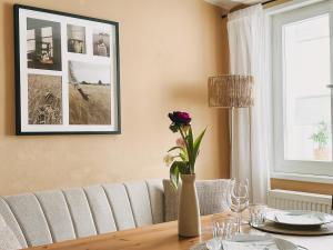 a dining room table with a vase of flowers on it at Denkmalsuites Quedlinburg in Quedlinburg