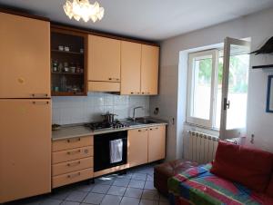 a kitchen with wooden cabinets and a stove top oven at Cinque Tomoli SINTROPICA in Ventotene
