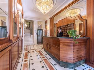 a woman standing behind a bar in a hotel lobby at Raeli Hotel Siracusa in Rome