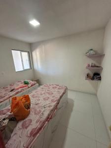 a small room with two beds and a window at Casa de praia Carneiros-Tamandaré in Tamandaré