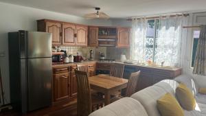 a kitchen with a table and a refrigerator at Le flamboyant rougeoyant in Saint-Louis