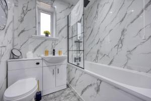 a white bathroom with a toilet and a sink at Charming Terrace House for Relaxing Retreat in Dumbarton +19 photos