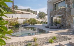 a garden with a swimming pool and a house at Elia Cove Luxury Villa II in Loutraki