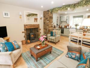 een woonkamer met een bank en een open haard bij River Dance Cottage in Leyburn