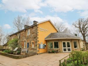een geel gebouw met een bord erop bij River Dance Cottage in Leyburn