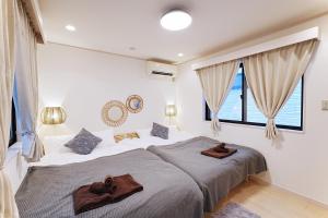 ein Schlafzimmer mit einem Bett, auf dem zwei braune Handtücher liegen in der Unterkunft European villa in Tokio
