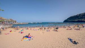 a large group of people on a beach at Villa R Relíquia in Machico