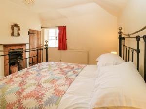 Un dormitorio con una cama y una chimenea. en 3 Malthouse Cottages, en Alton