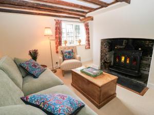 Una sala de estar con un sofá y una chimenea. en 3 Malthouse Cottages, en Alton
