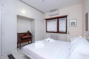 ローマにあるMonteverde Family Apartment with free garageの白いベッドルーム(ベッド2台、窓付)