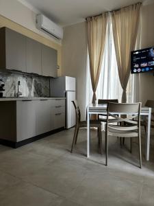 Una cocina y un comedor con mesa y sillas. en Suite della Marchesa, en Génova