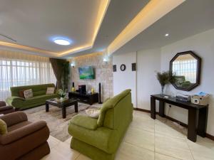 a living room with green furniture and a mirror at Seaview Comfort Apartment in Mombasa