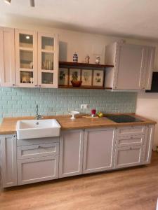a kitchen with white cabinets and a sink at Charme nel borgo - Appartamento Maria in Corniglio