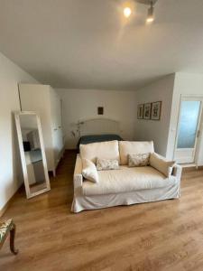 a living room with a white couch and a mirror at Charme nel borgo - Appartamento Maria in Corniglio +12 photos