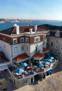 an aerial view of a building with tables and umbrellas at Villa Cascais Boutique Hotel in Cascais