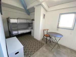 a small room with a table and a bunk bed at Joli Duplex résidence Atlantis accès direct plage in Le Barcarès