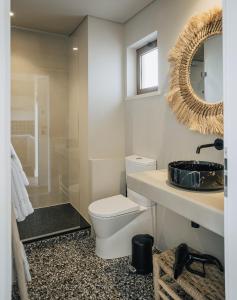 a bathroom with a toilet and a sink and a mirror at AlmaLusa Comporta in Comporta