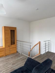 a living room with a couch and a stair case at Wunderschöne Maisonette Ferienwohnung in Leipzig Taucha 2 u 3 OG Mitte in Taucha