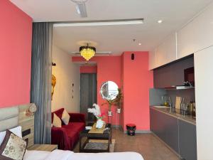 a living room with red walls and a red couch at Supernova River View Studio in Noida