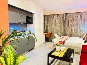 a living room with a bed and a table at Supernova River View Studio in Noida