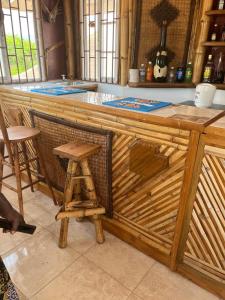 a wooden bar in a kitchen with a stool at Kokojo Villa in Black River +15 photos