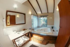 a bathroom with a tub and a sink and a mirror at Serra Bela Eco Pousada in Urubici +244 photos