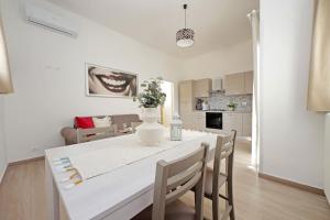 a kitchen and dining room with a white table and chairs at Elegante e Comodo - A pochi minuti dall'Aeroporto in Fiumicino